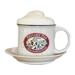 A cappuccino with a tall cap of foam in a Morton’s Moo mug and saucer