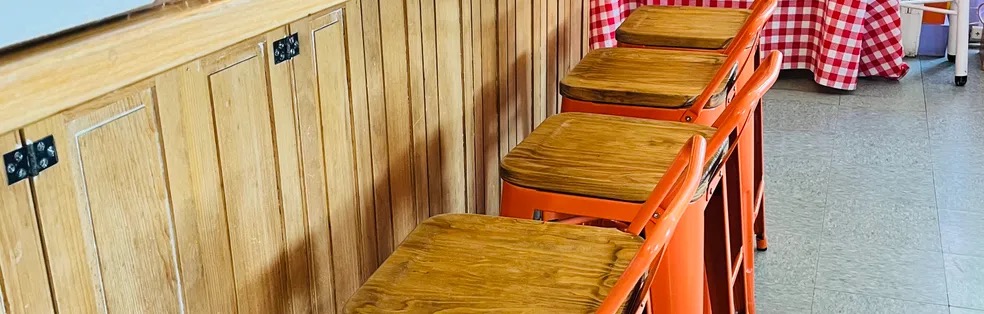 Orange stools along the wooden counter
