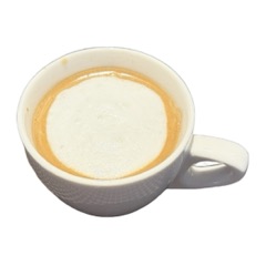 A macchiato topped with foamed milk in a white cup