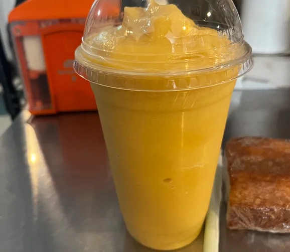 A mango smoothie in a lidded cup